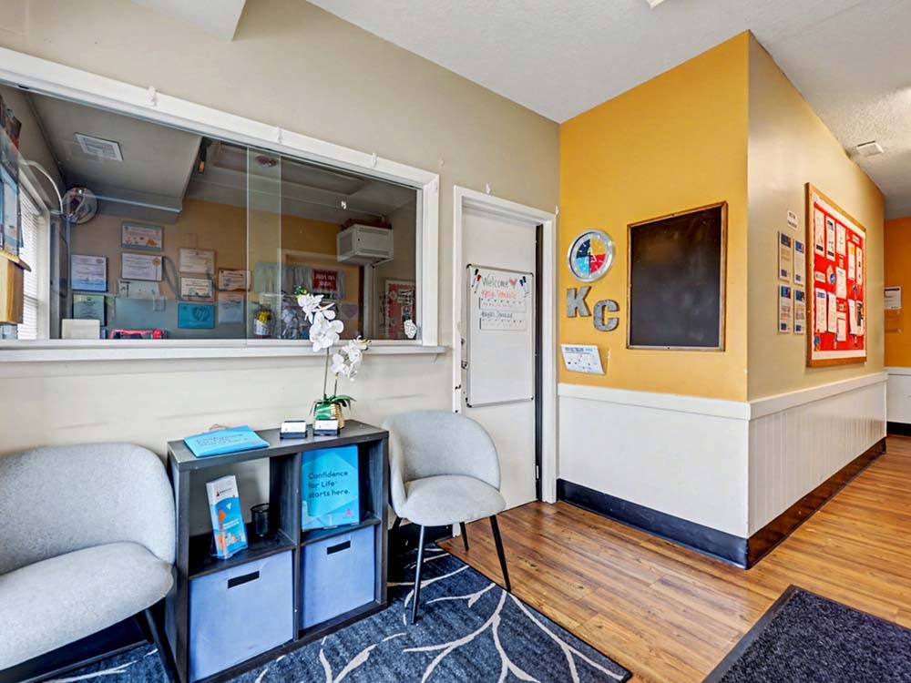 Waiting area with chairs, a shelf, and a service window