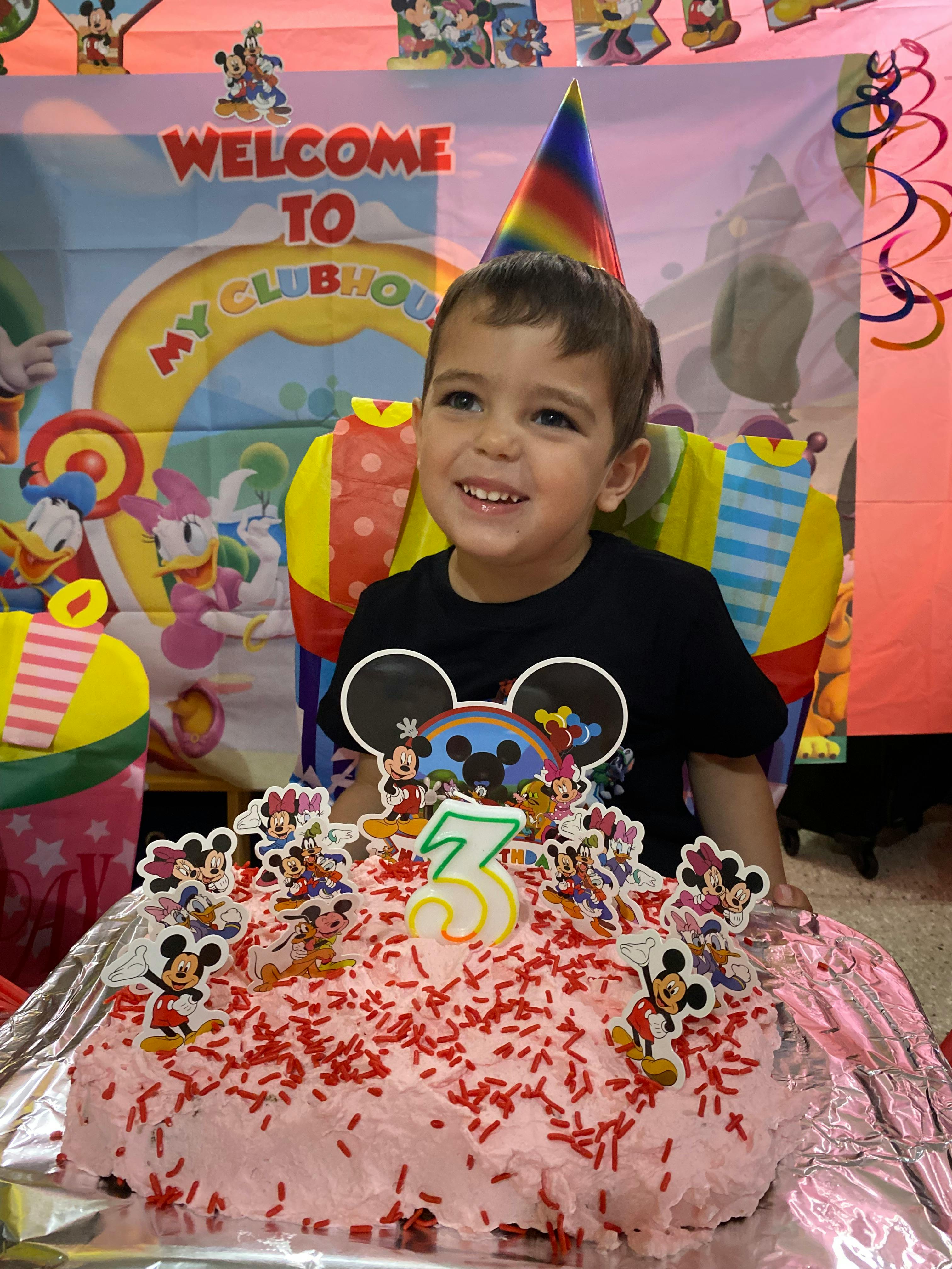 Child with a birthday cake with a number 3 candle