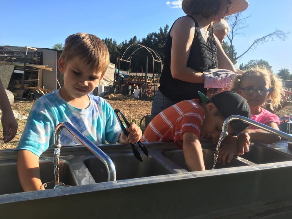 Children washing hands at an outdoor sink