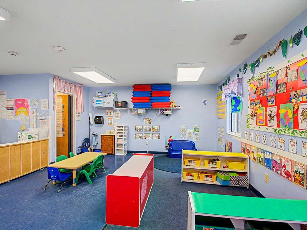 Colorful classroom with child-sized furniture and artwork on the walls
