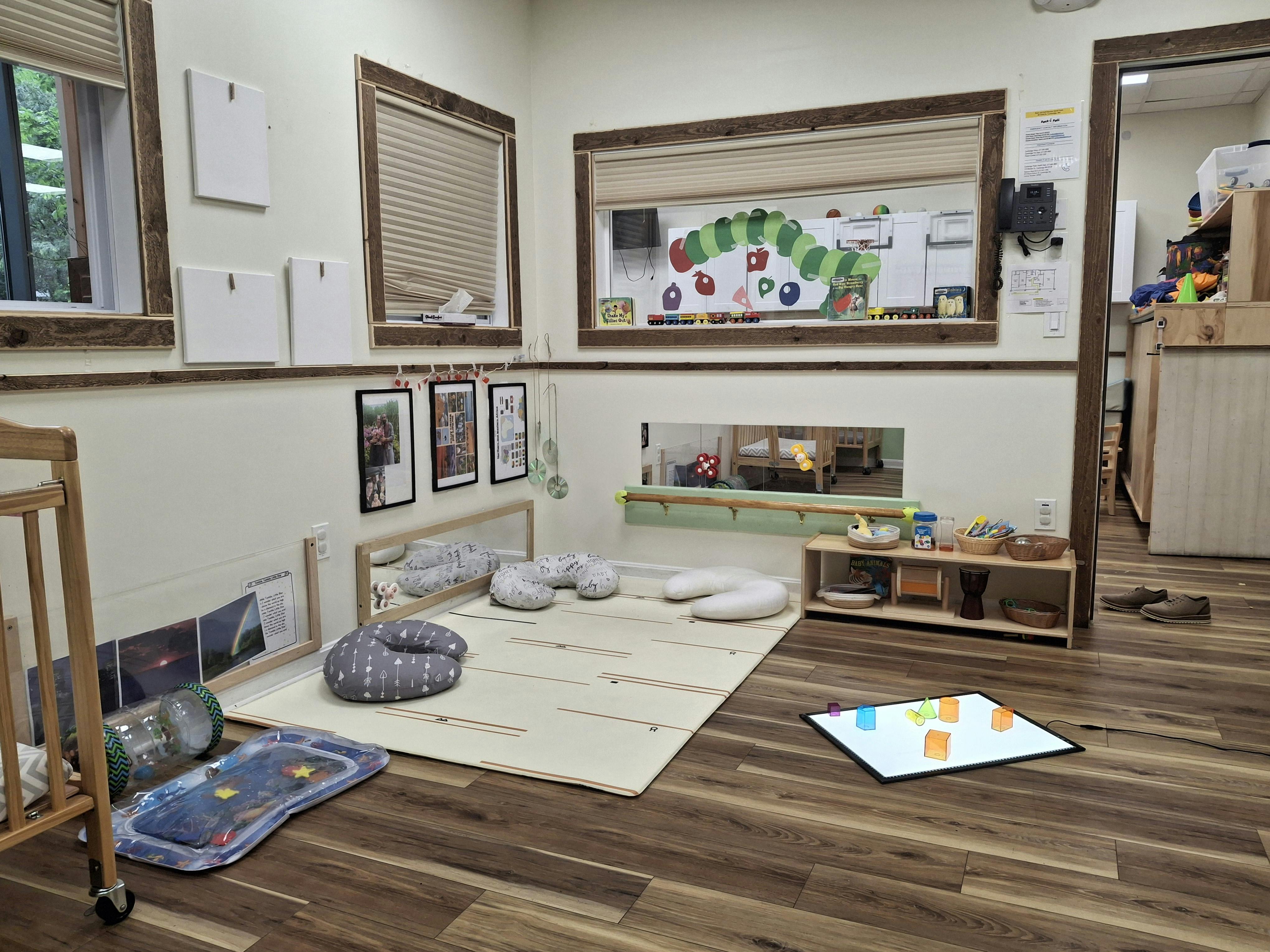 Infant room with crib, floor mat, pillows, and activity board