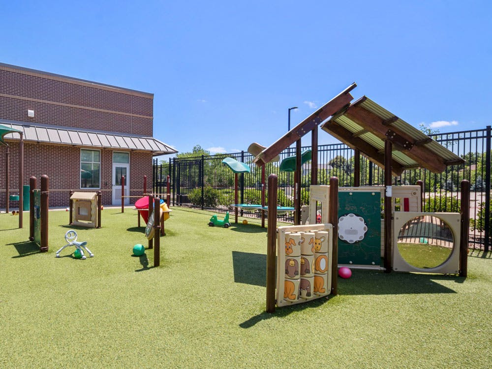 Outdoor playground area with play structures on artificial turf