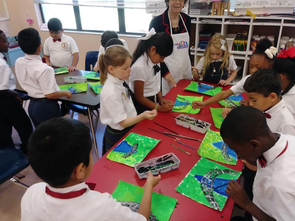 Children painting at a table in a classroom