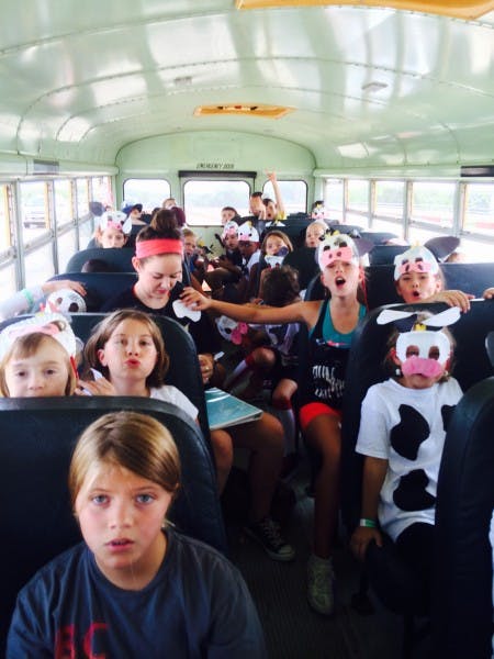 Children wearing cow masks and costumes on a school bus