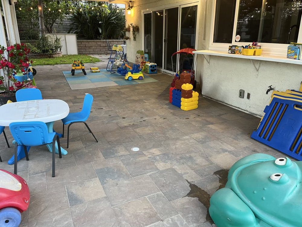Outdoor patio with children's play equipment and small table with chairs