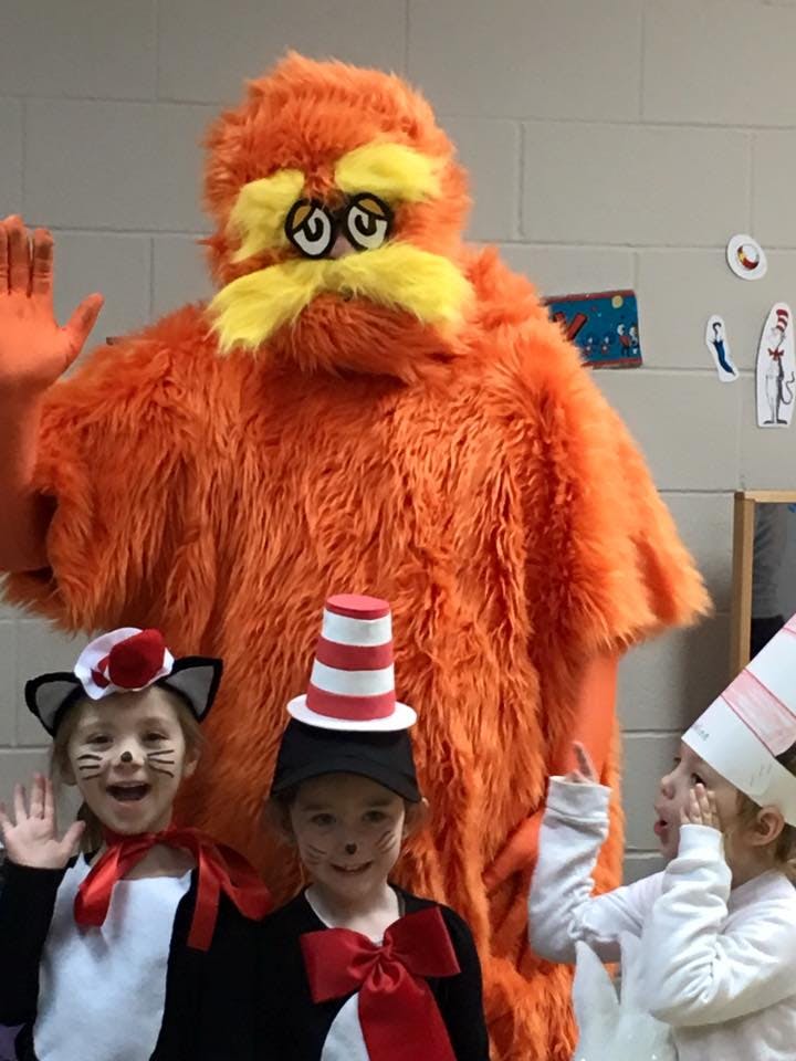 Person in orange furry costume with three children in costumes