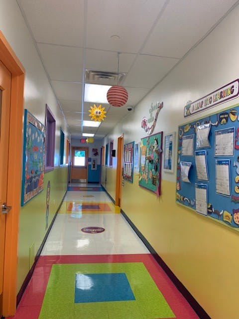 Hallway with colorful walls and floor, decorated with bulletin boards and hanging ornaments