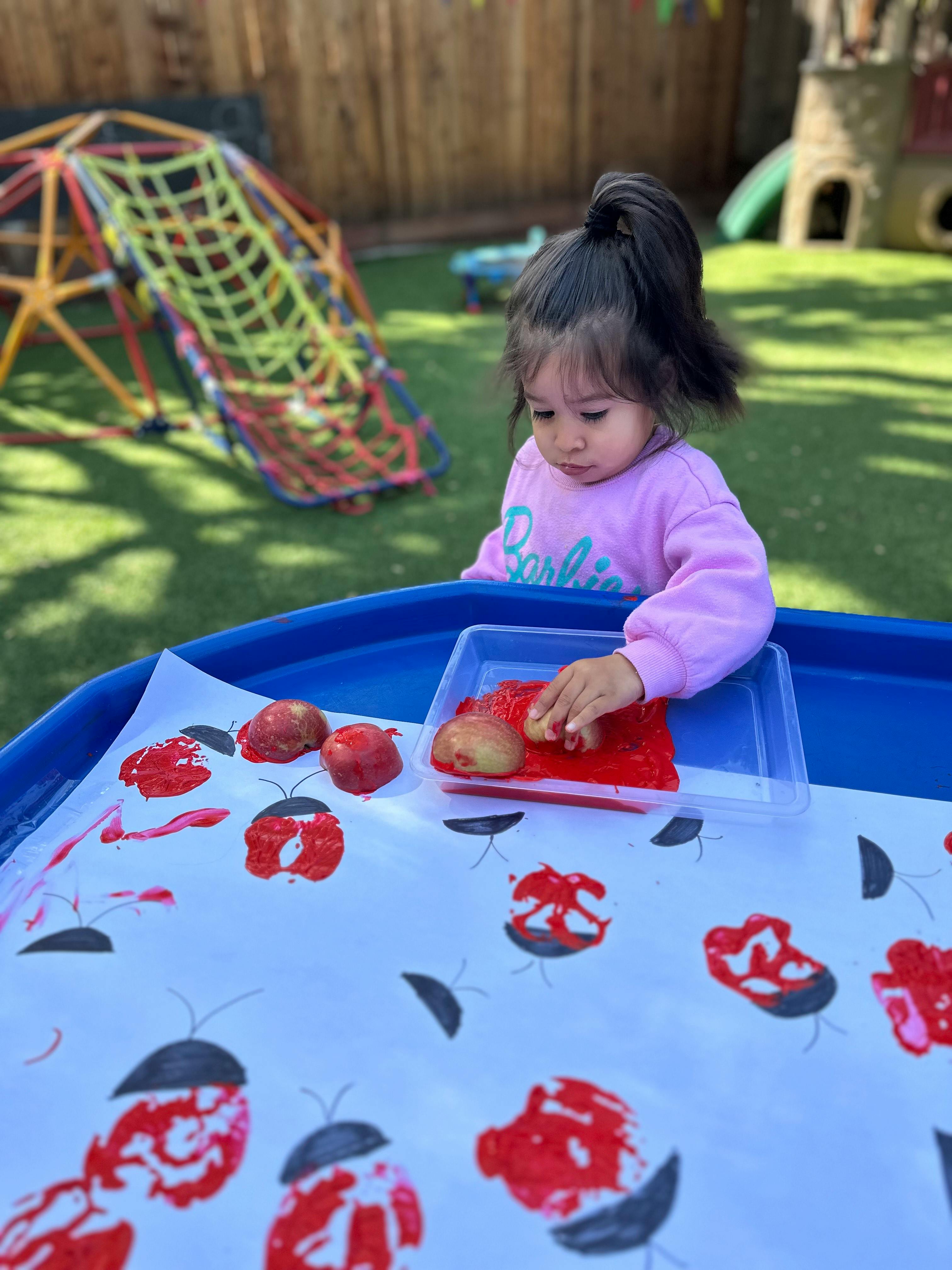 Child making apple prints on paper