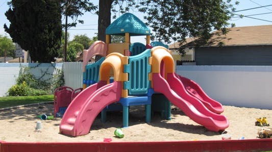 Playground structure with multiple slides in a sandbox