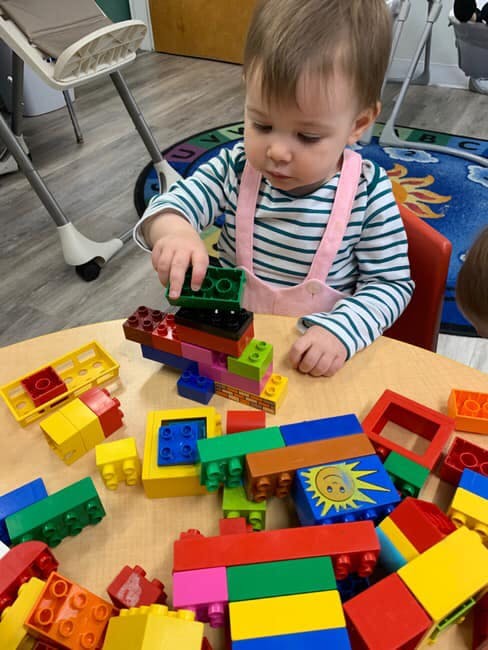 Child playing with colorful building blocks on a table