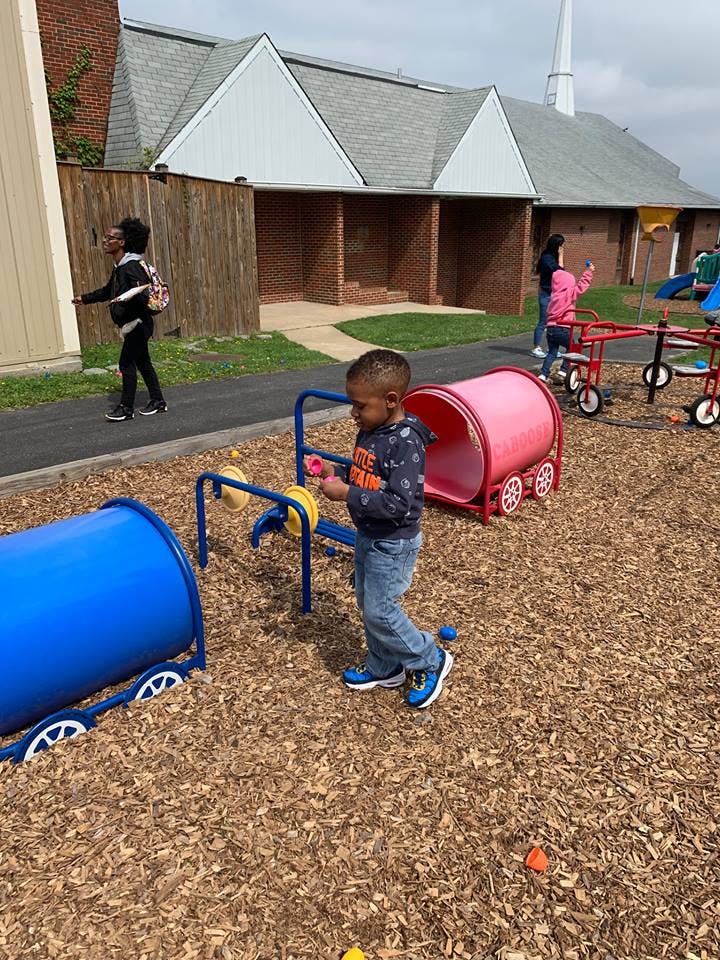 Child playing with outdoor toys on a wood chip surface
