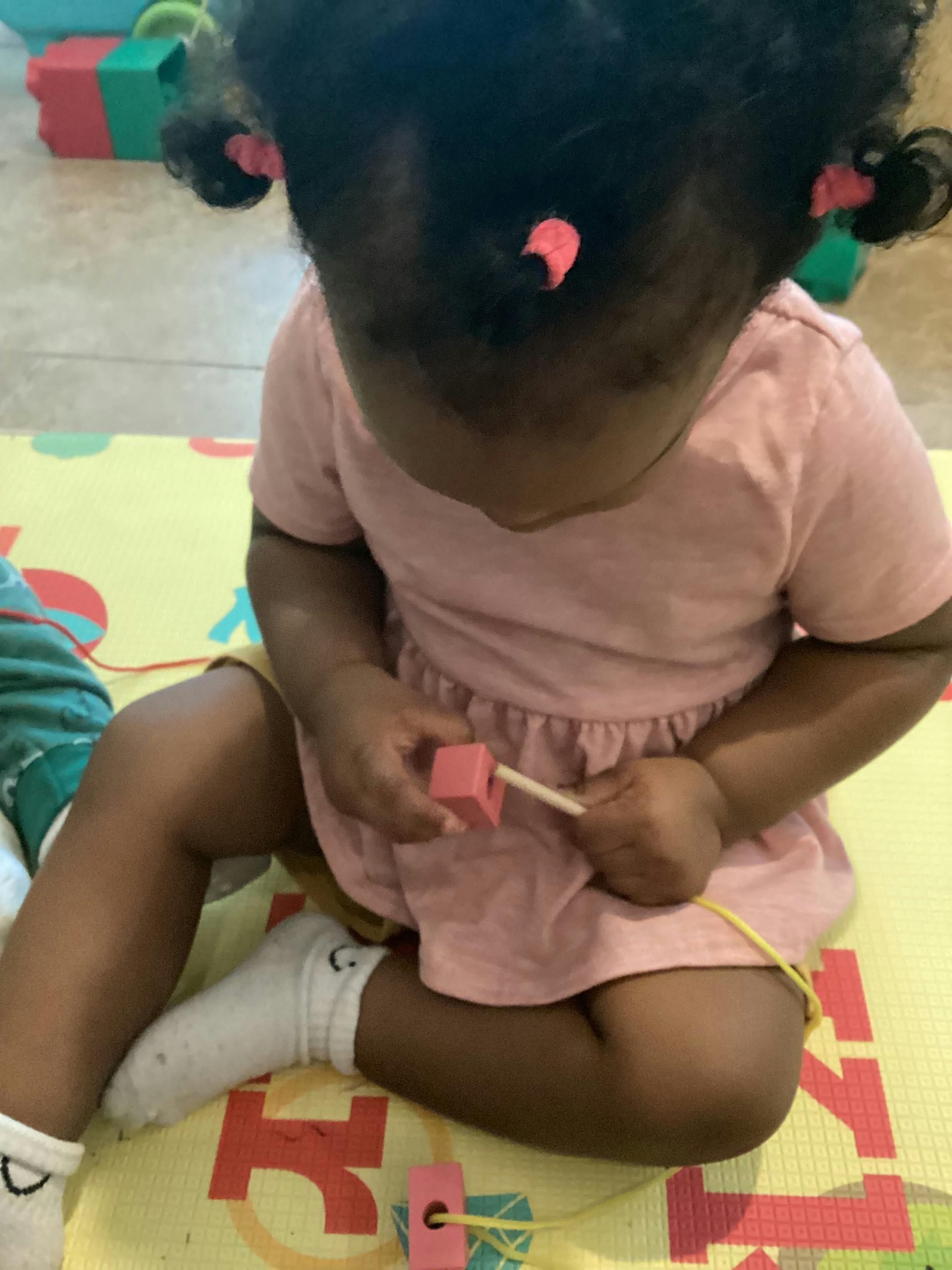 Child playing with a lacing toy