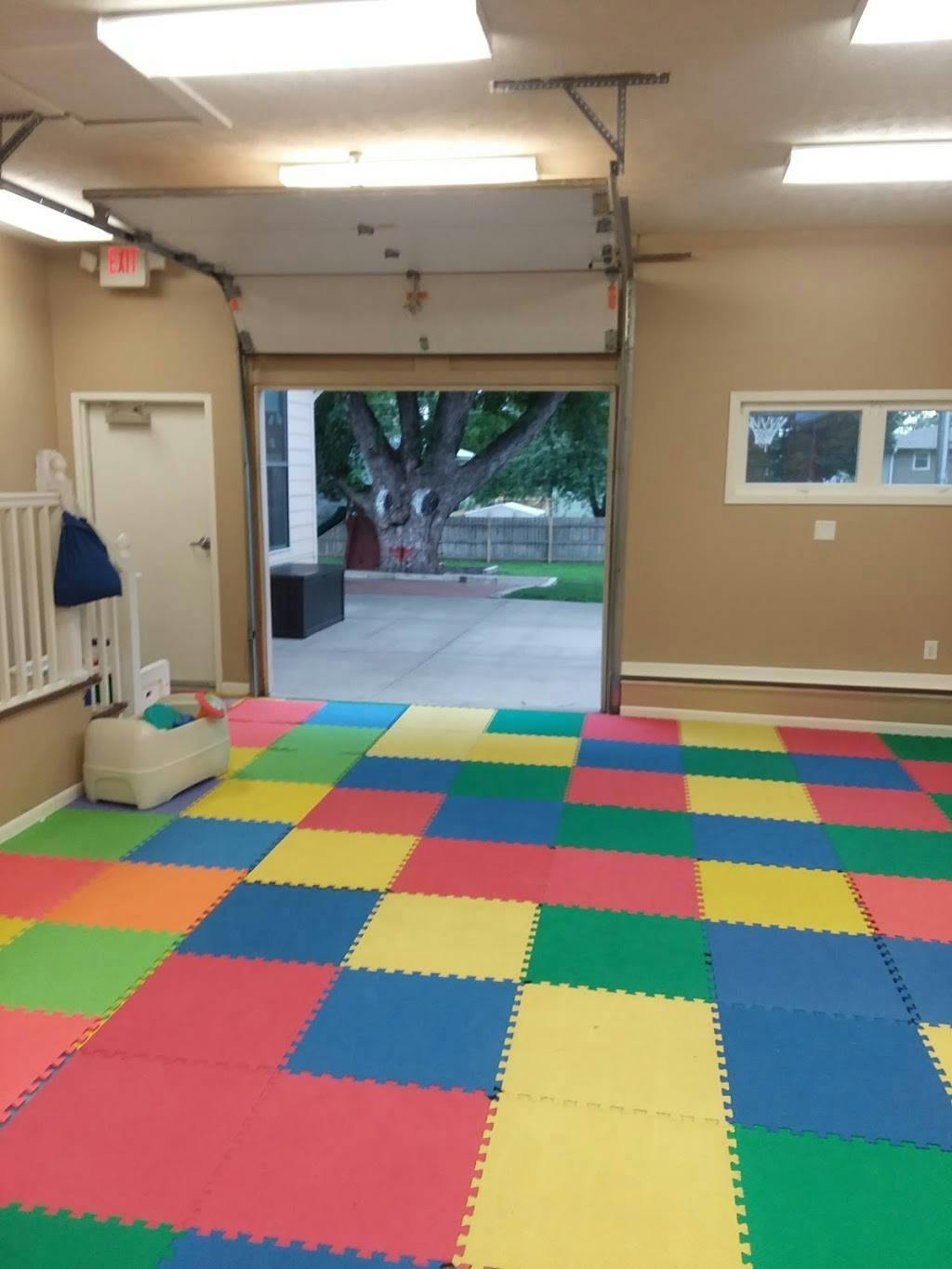 Room with colorful interlocking floor mats and an open garage door