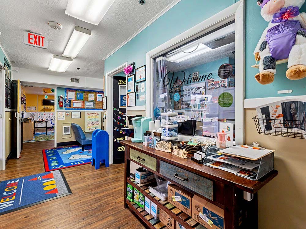 Hallway in a childcare center with a reception window and classroom entrance