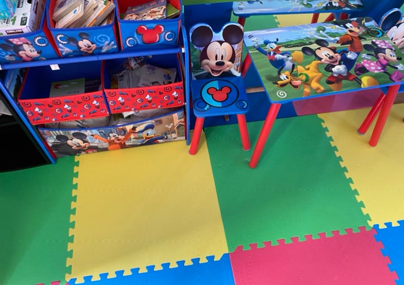 Mickey Mouse themed storage unit, chair, and table on a colorful floor