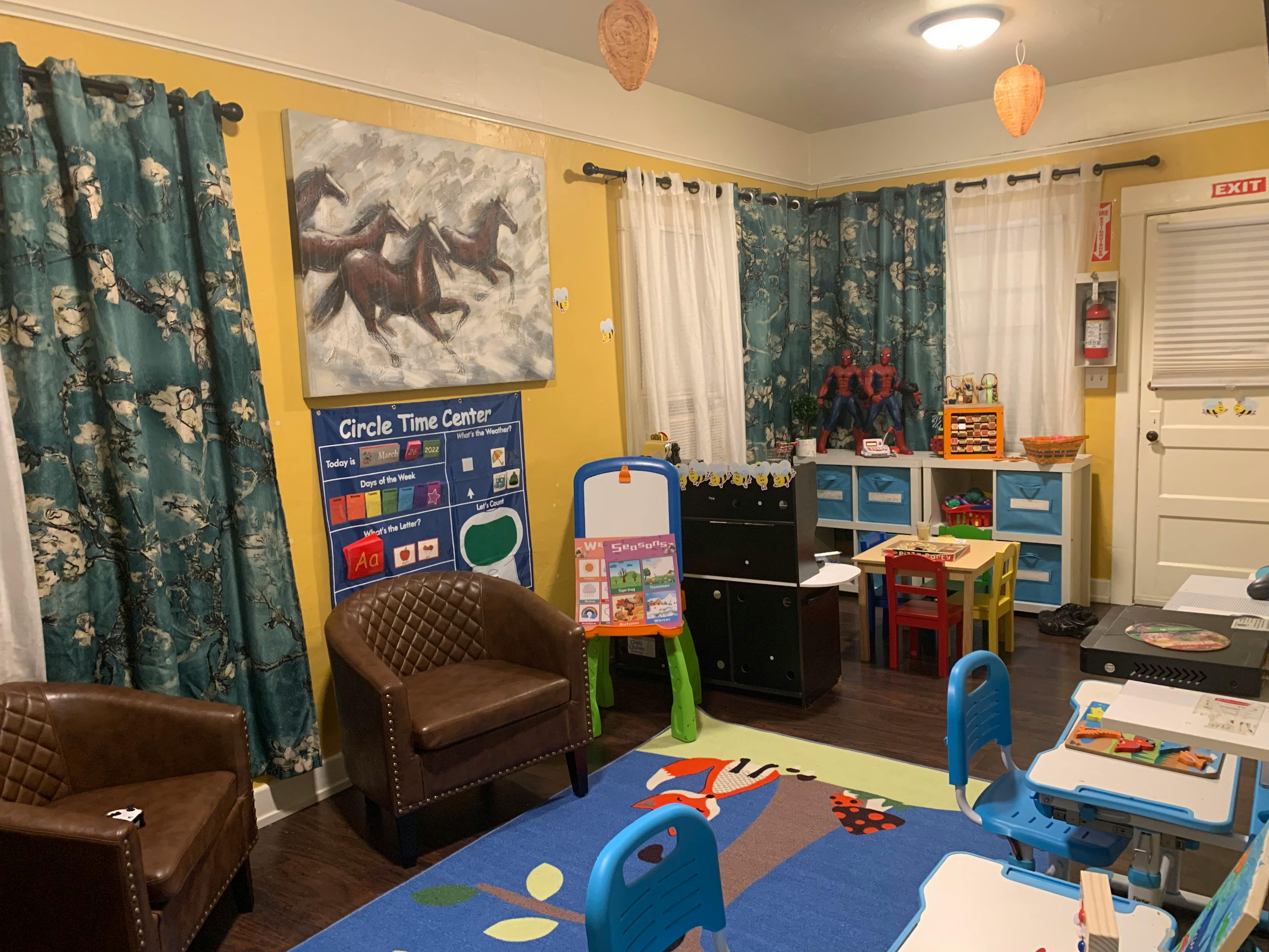A room with a blue rug, two brown chairs, and a white board easel