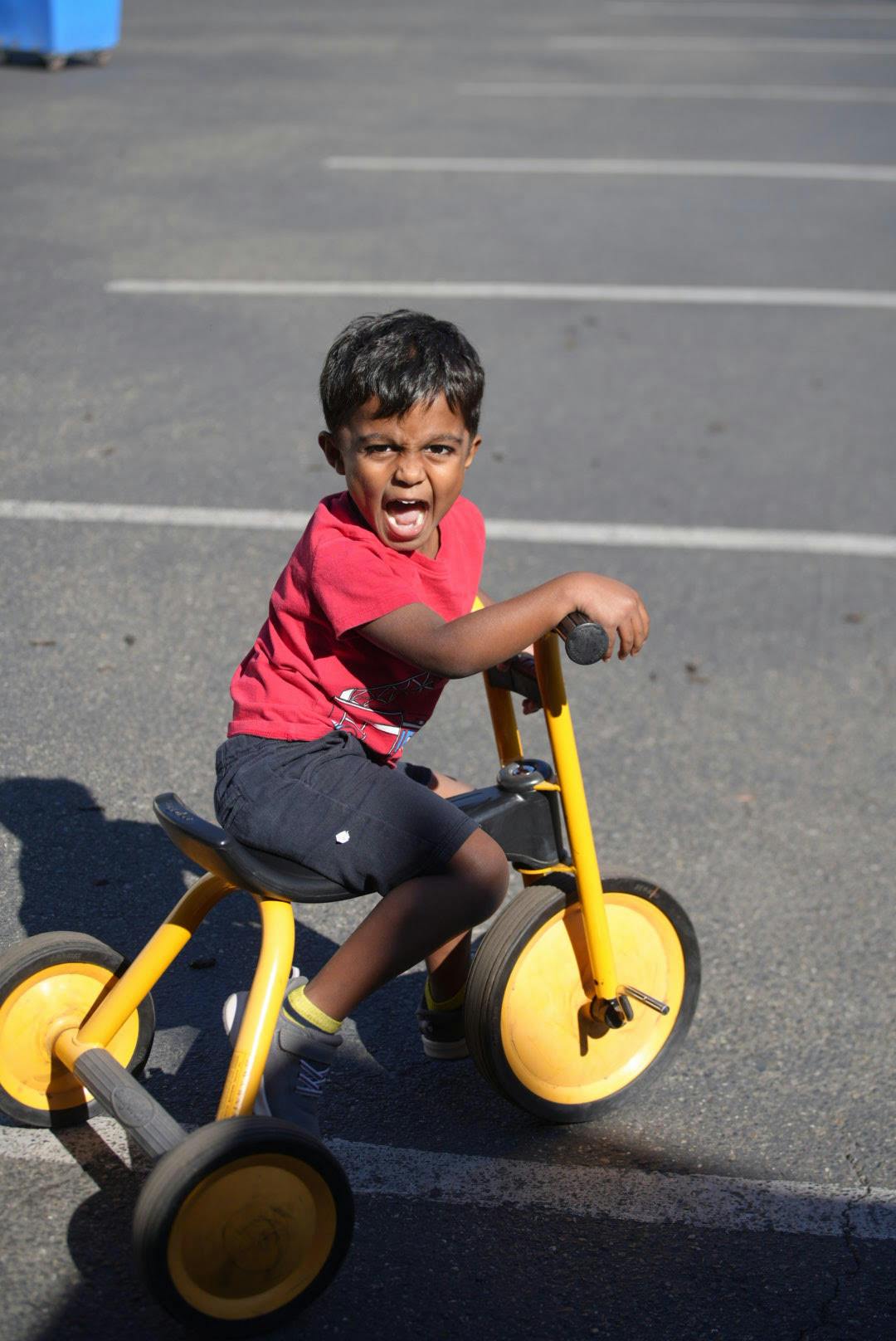 Child riding a yellow tricycle