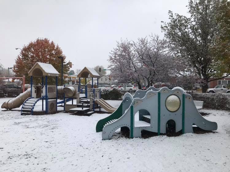 Snow-covered playground with slides and climbing structures