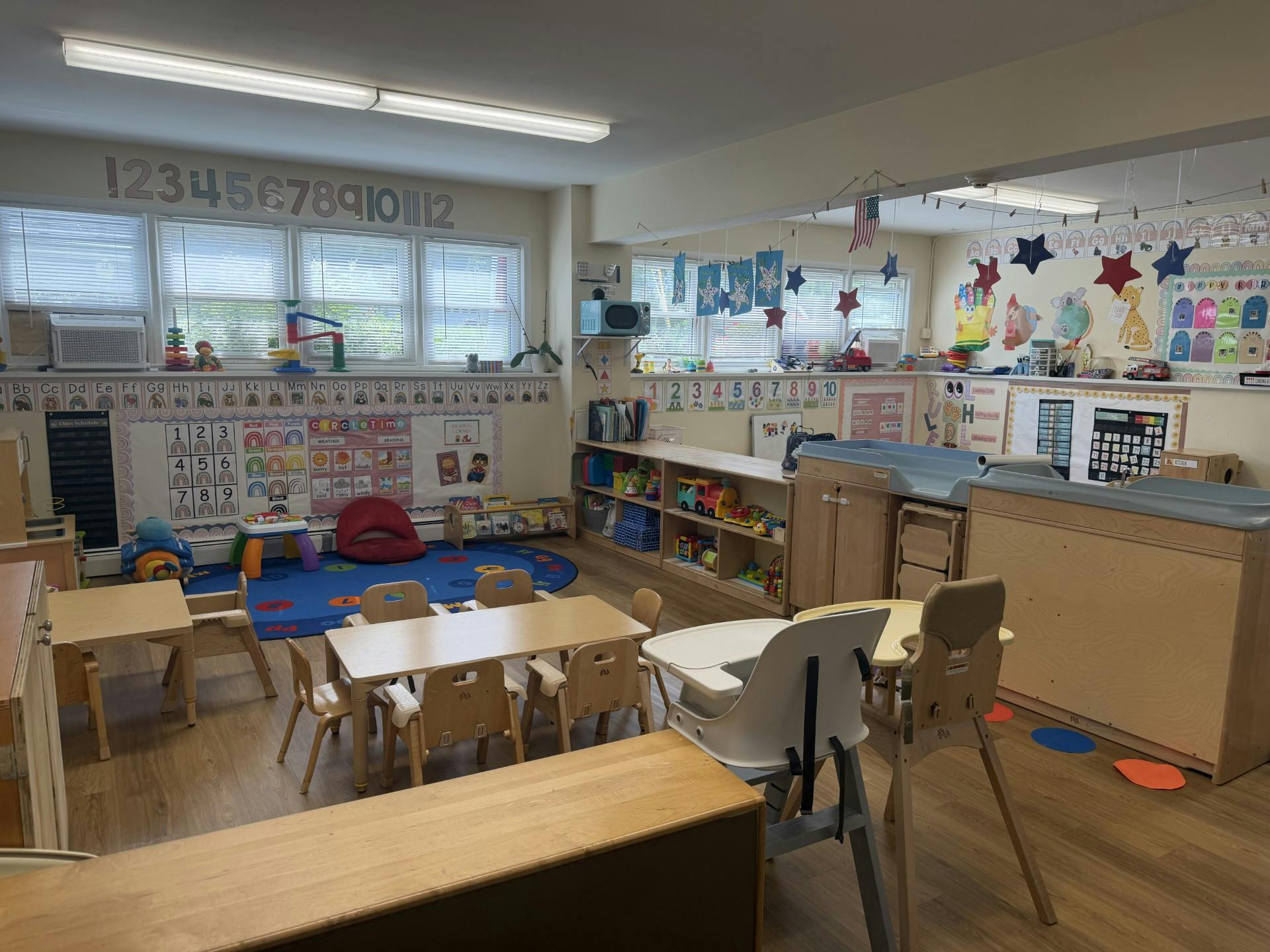Classroom interior with small tables, chairs, and educational wall displays