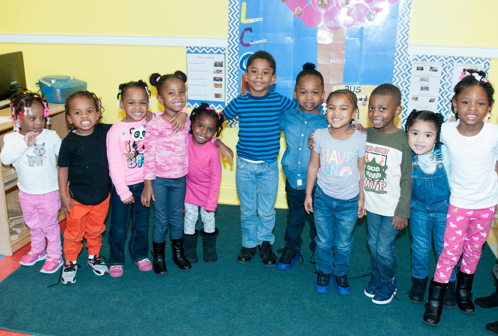 Group of children standing together in a classroom
