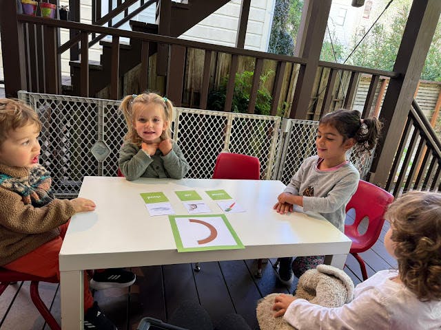 Four children sitting around a table with cards