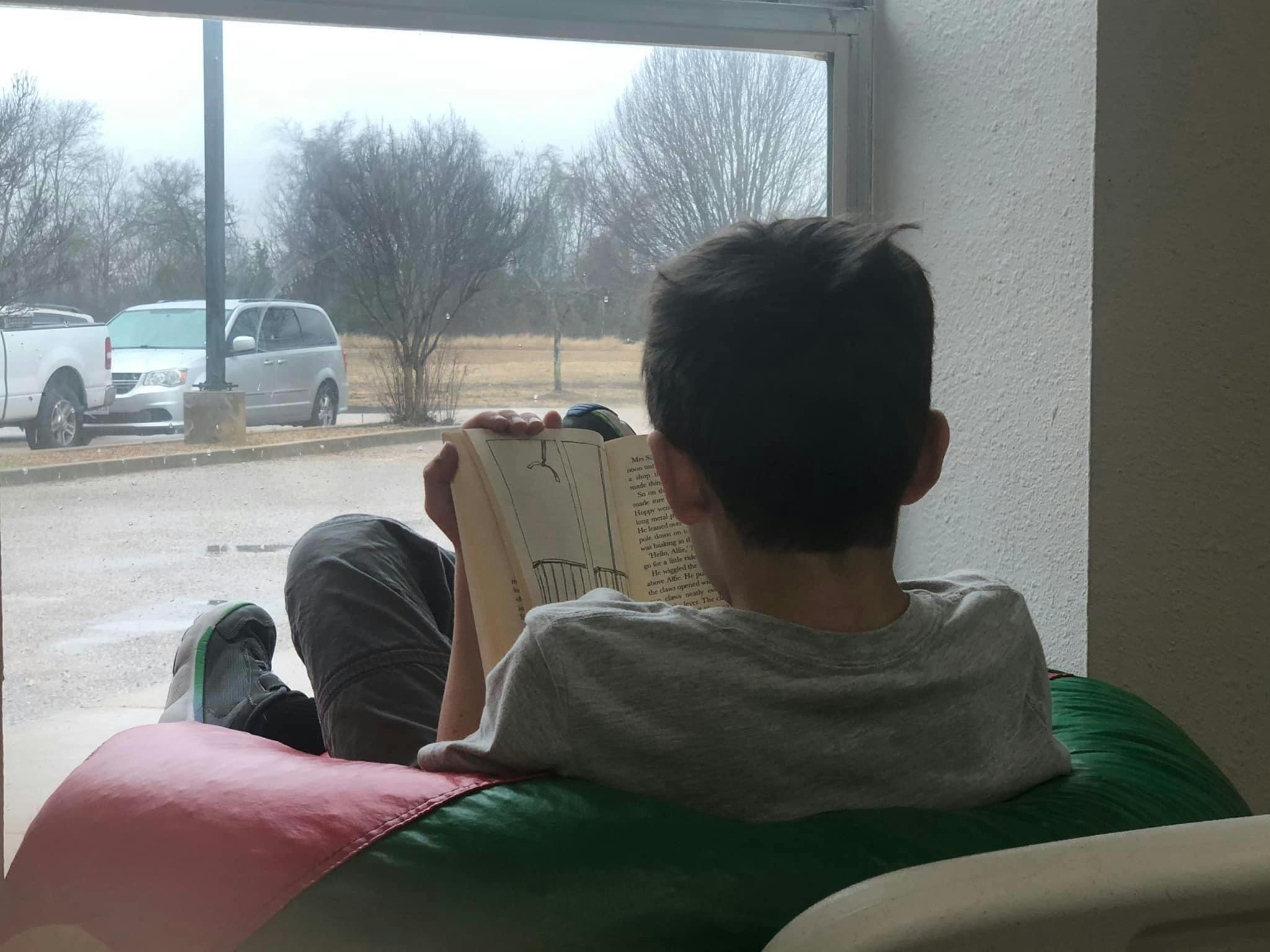 Child reading a book while sitting on a beanbag chair