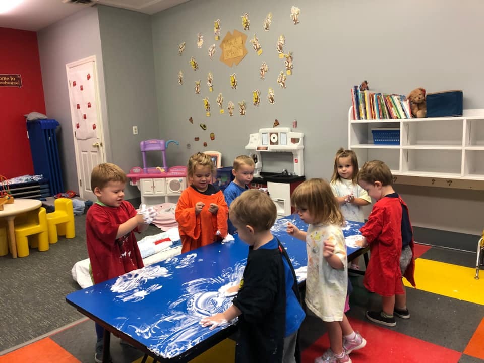 Children gathered around a table doing an art activity