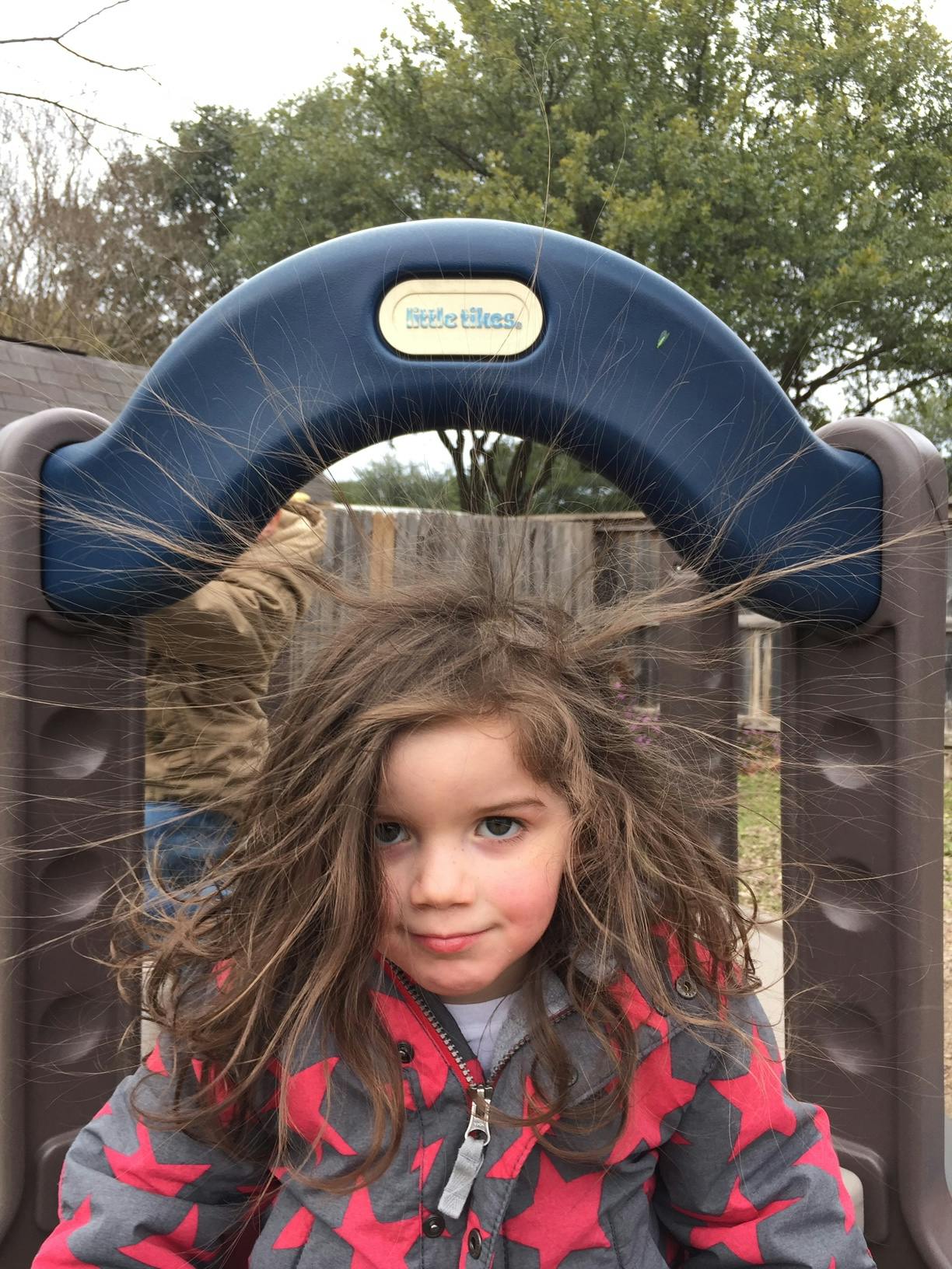 Child with static hair on a playground