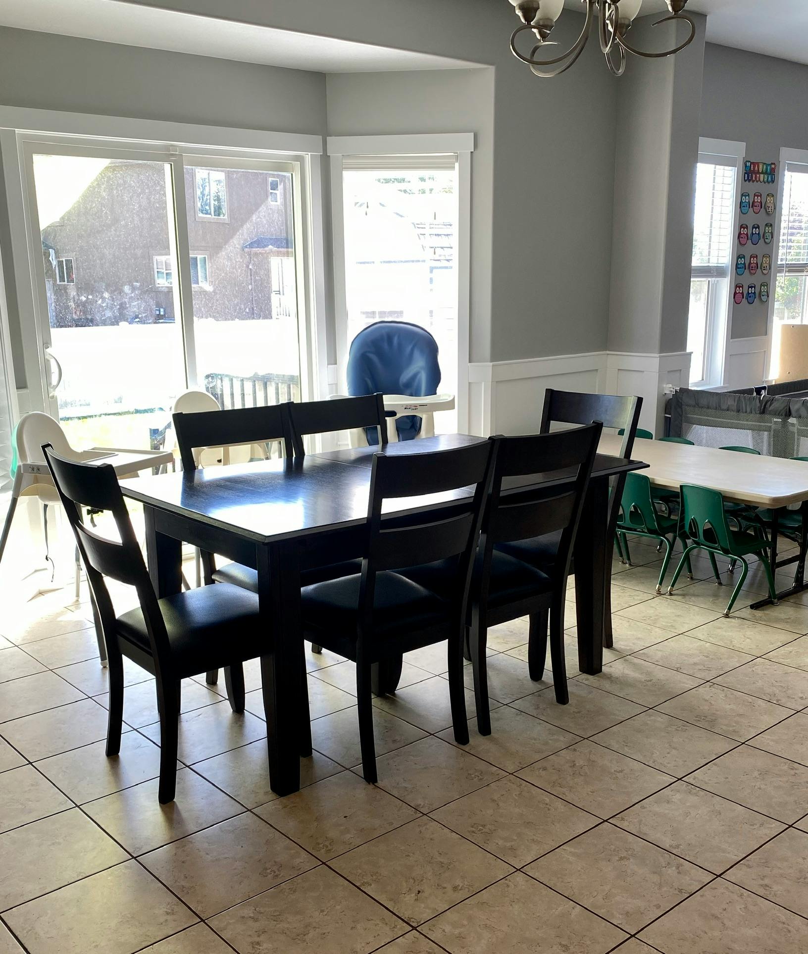 Dining room with a large dark table and chairs, tiled floor