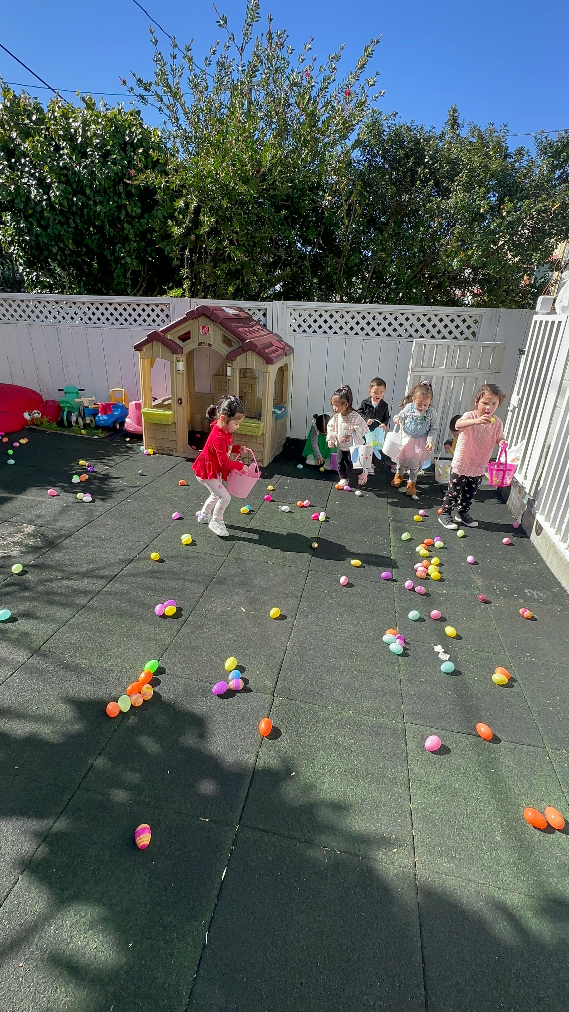 Children collecting colorful eggs on a playground