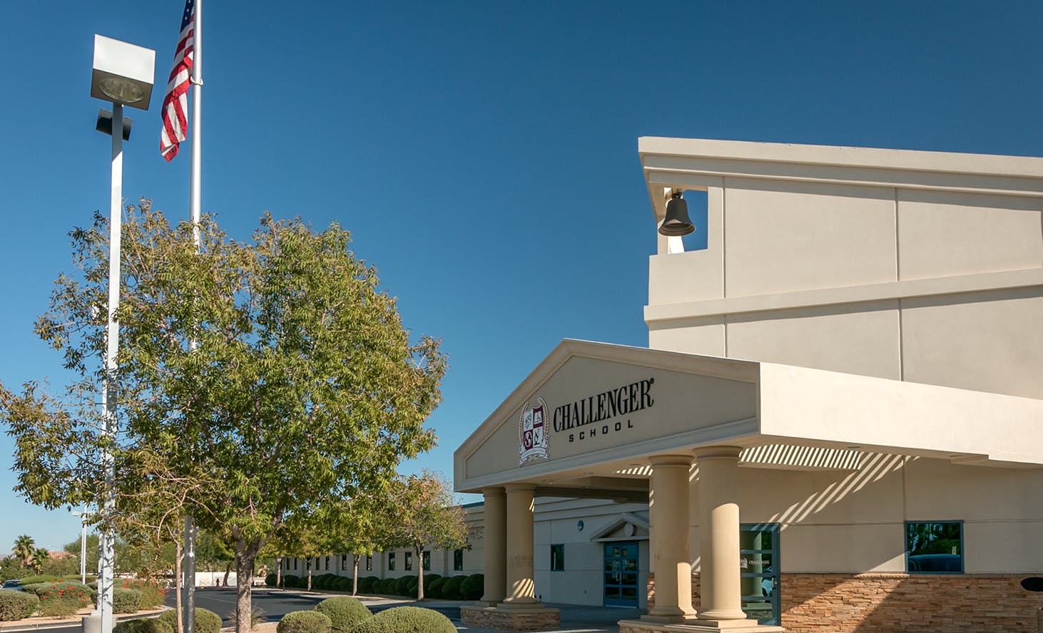 Building entrance with "CHALLENGER SCHOOL" sign and American flag