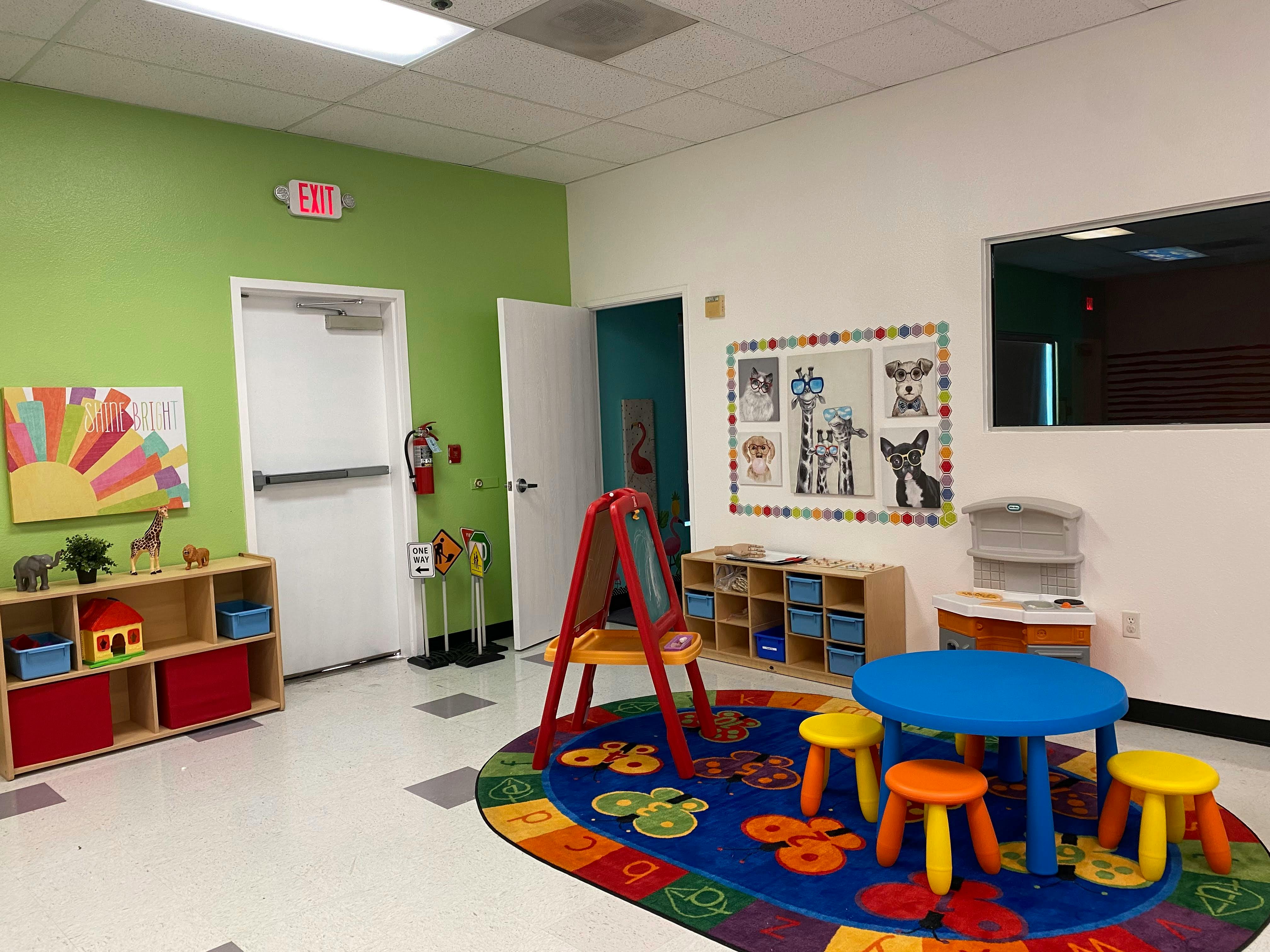 Classroom with small blue table and stools on a colorful rug