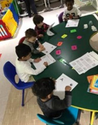 Children sitting at a table doing schoolwork