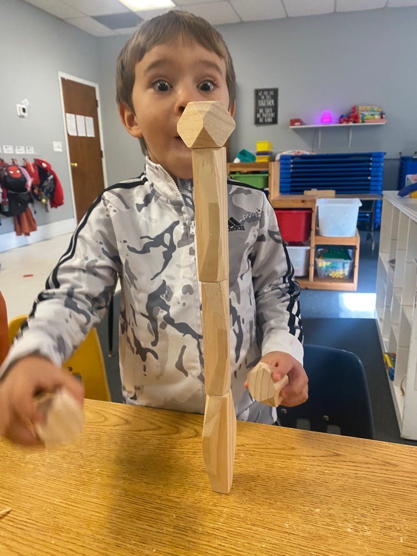 Child playing with wooden blocks at a table