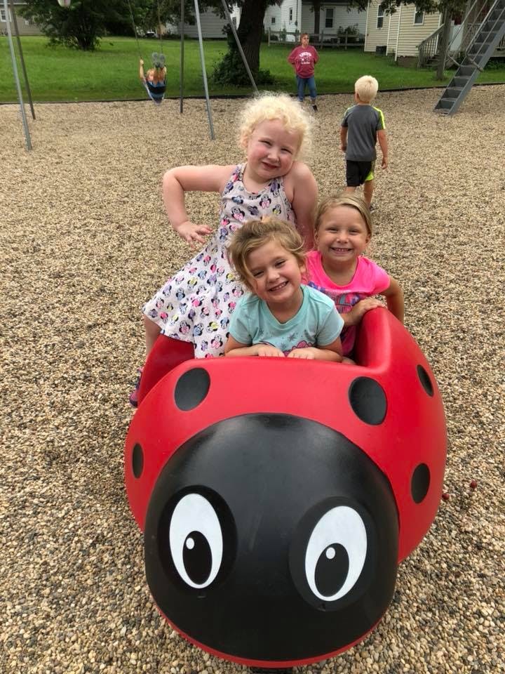 Three children on a ladybug playground ride