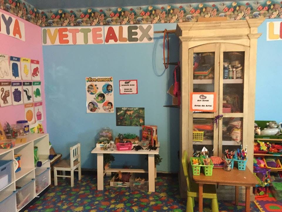 Classroom with small tables, chairs, and storage shelves