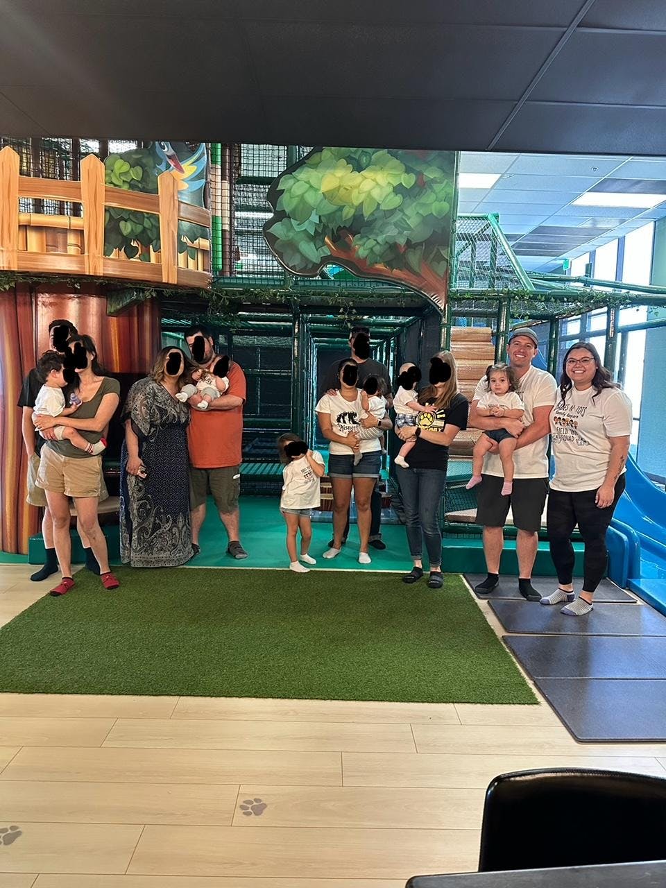 Group of people holding children in an indoor play area