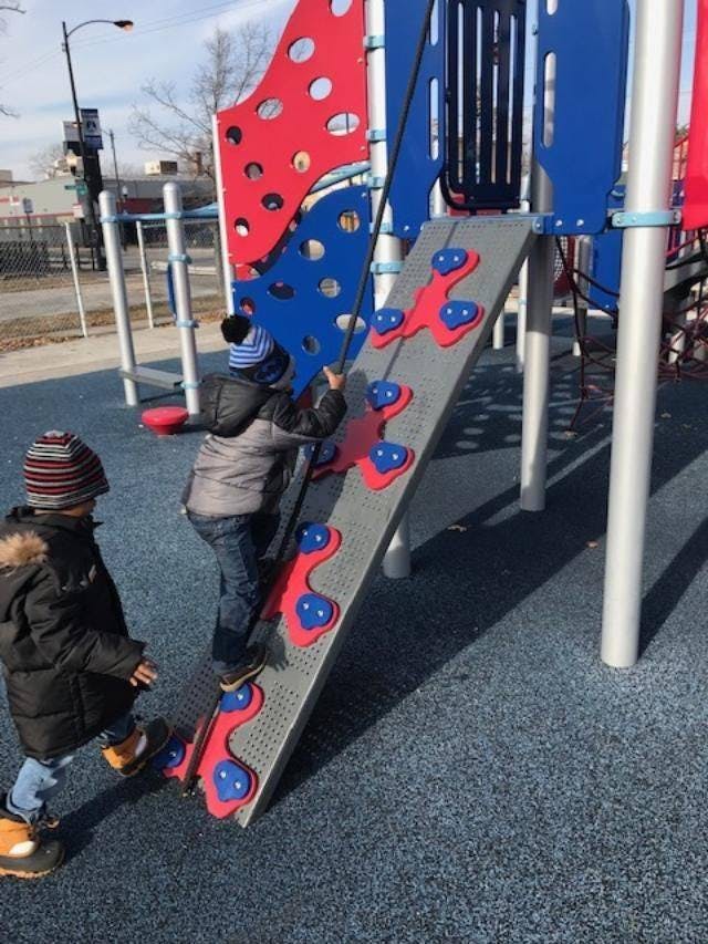 Two children on a playground climbing structure