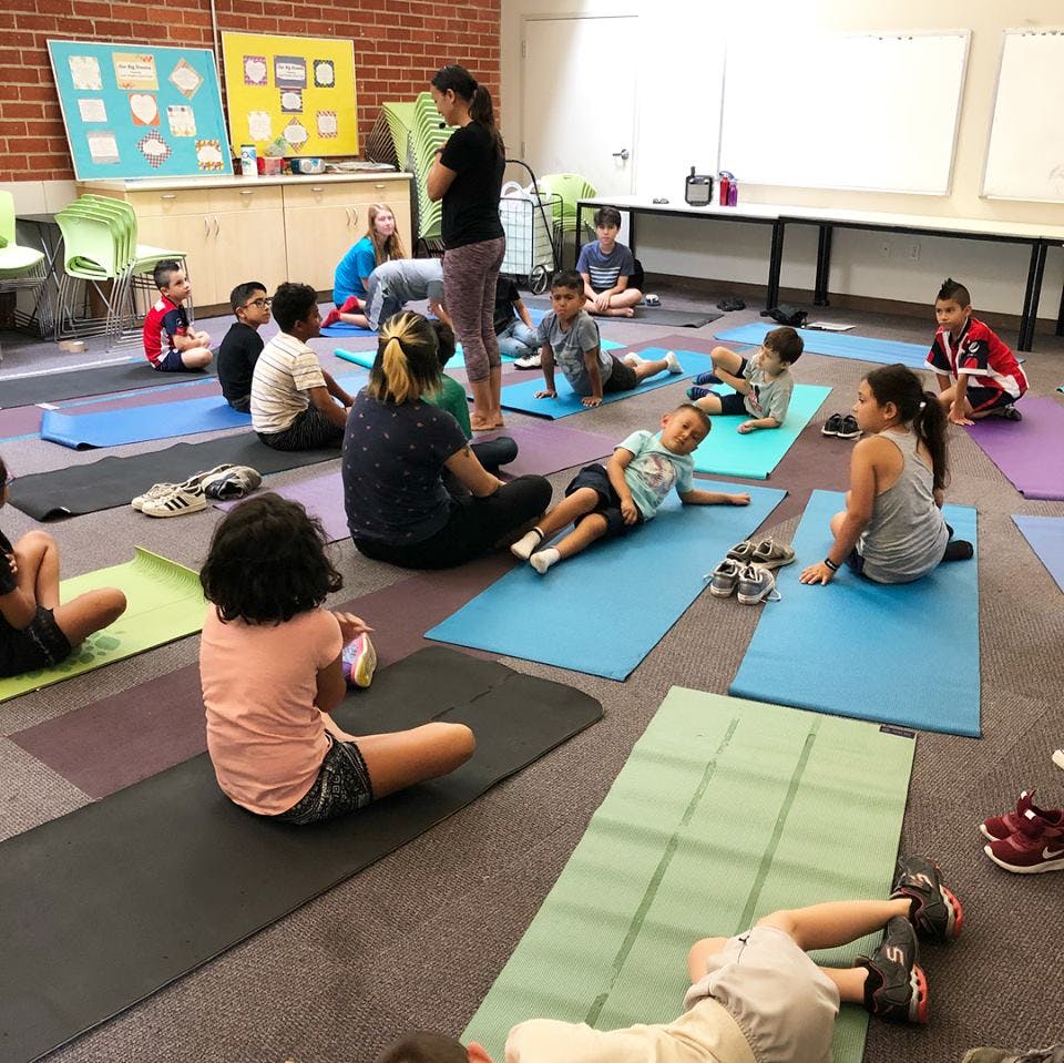 Adults and children on yoga mats in a room