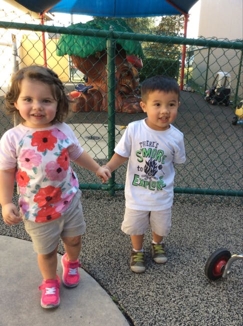 Two children holding hands on a playground