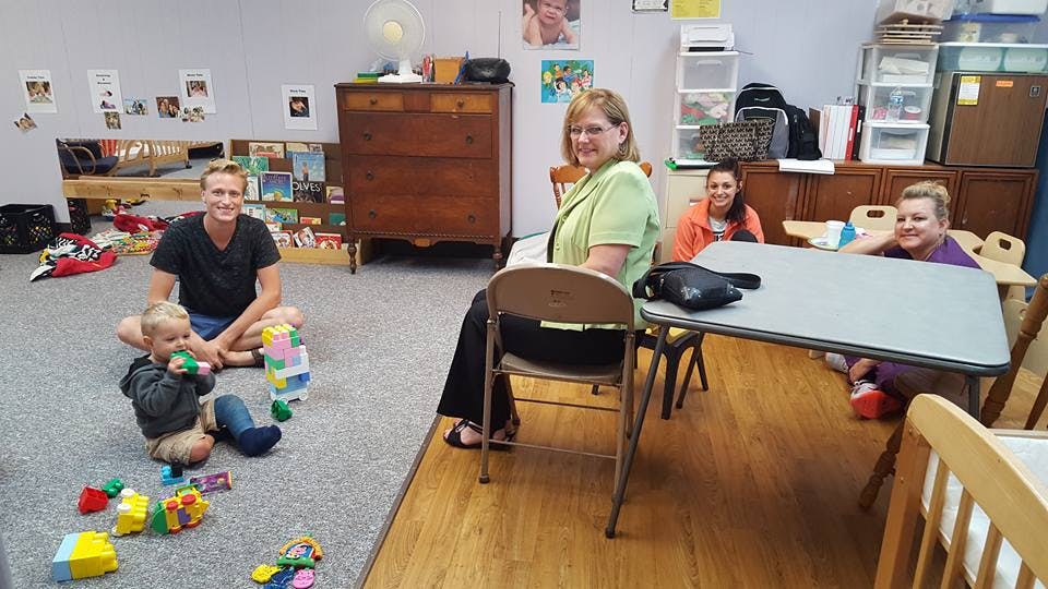 Adults and a child in a room with toys