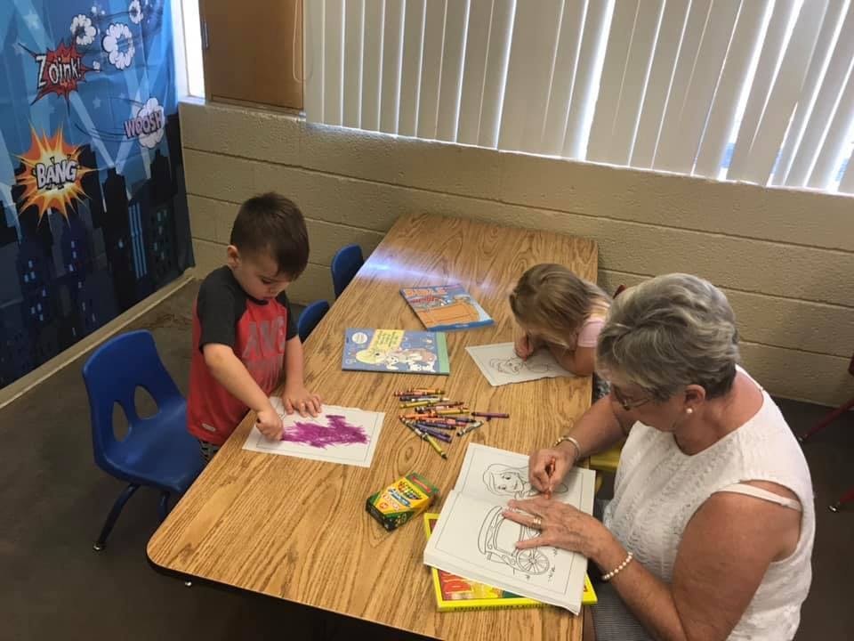 Adult and two children coloring at a table