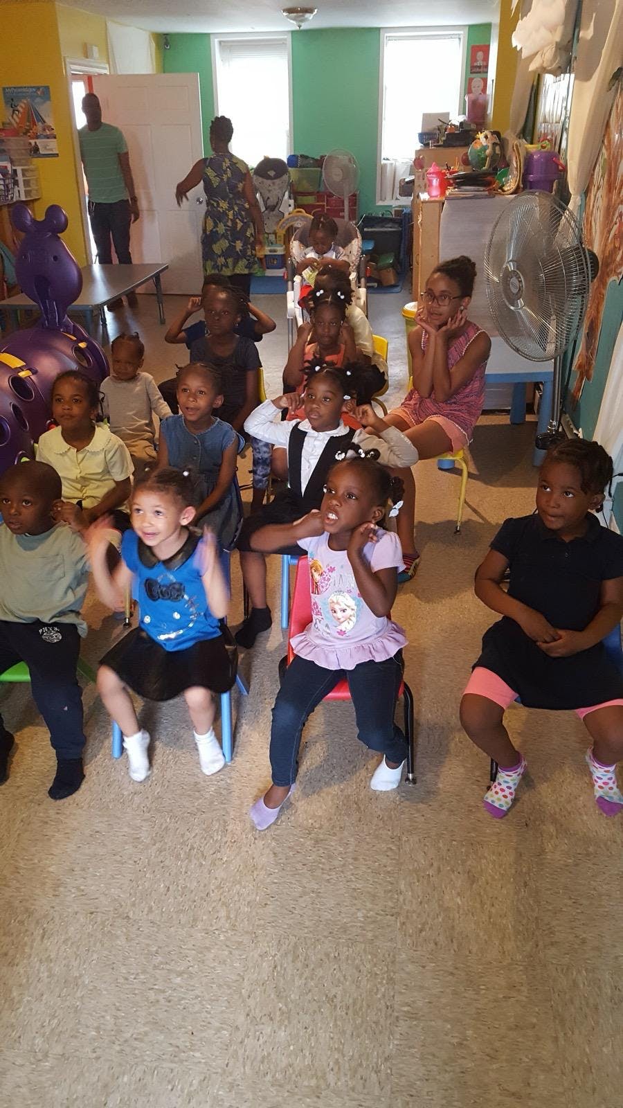 Group of children sitting in chairs in a classroom