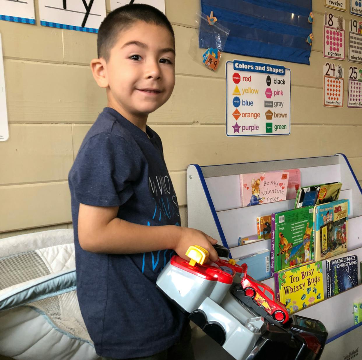 Child holding a toy in a classroom