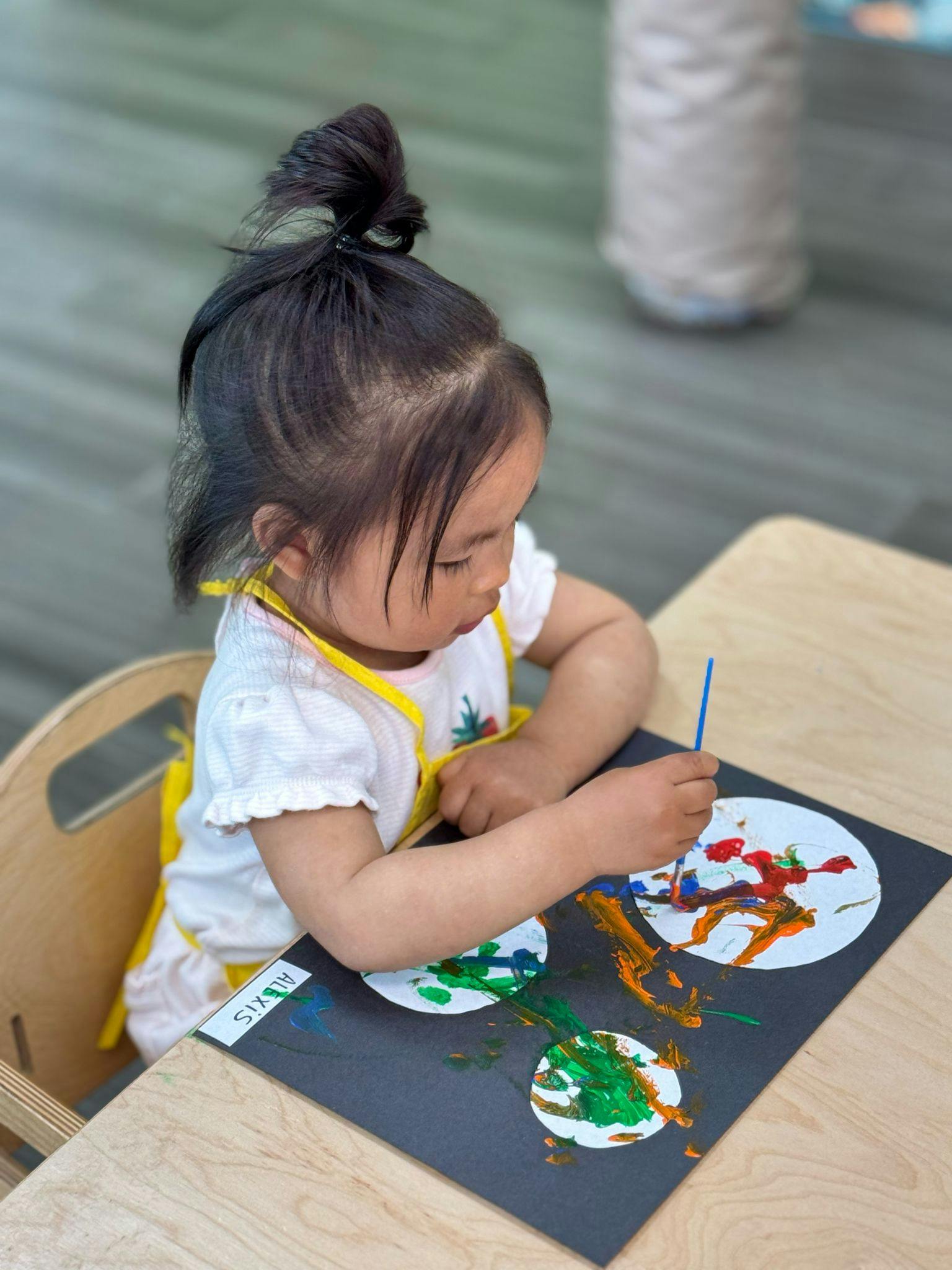 Child painting on paper at a table