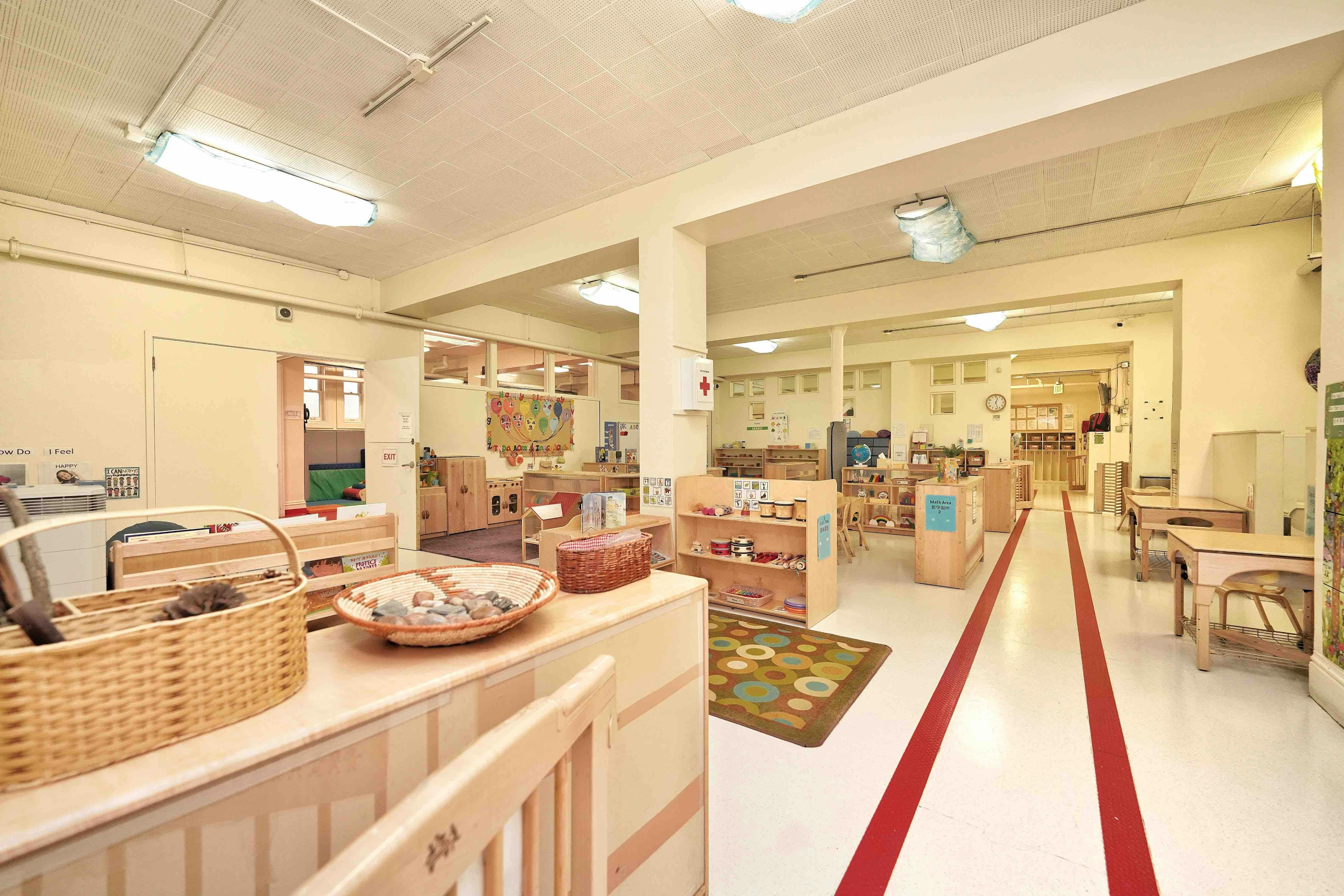 Empty preschool classroom with wooden shelves and learning materials