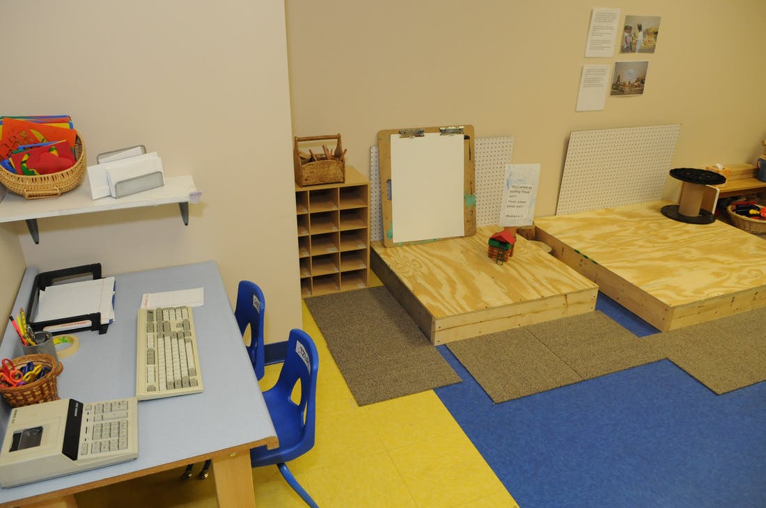 Classroom with tables, chairs, and wooden play structures