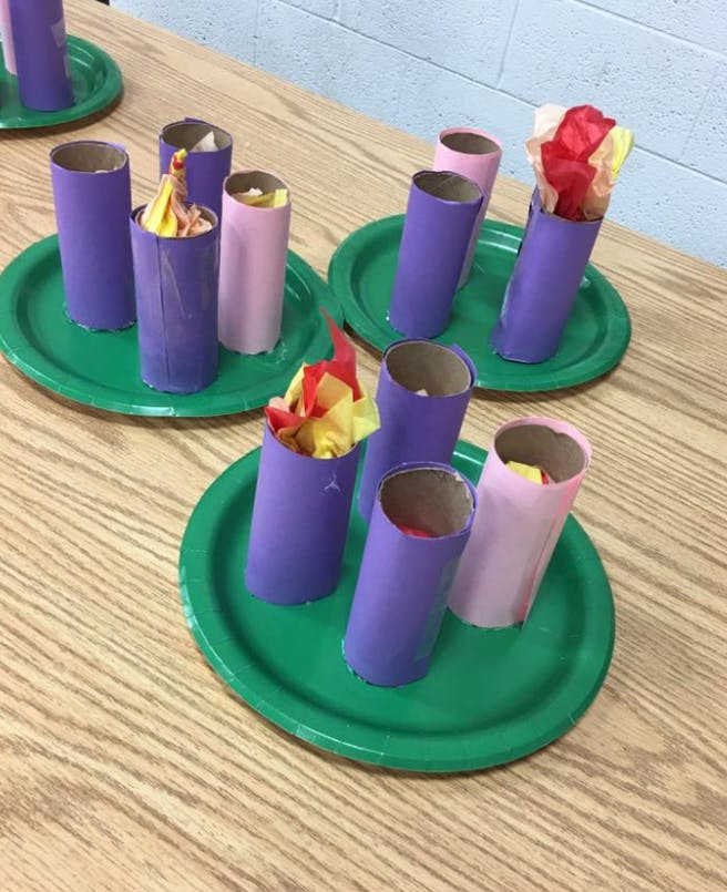 Crafts made from paper tubes and tissue paper on green plates
