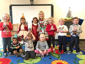 Adult and children posing for a photo in a classroom