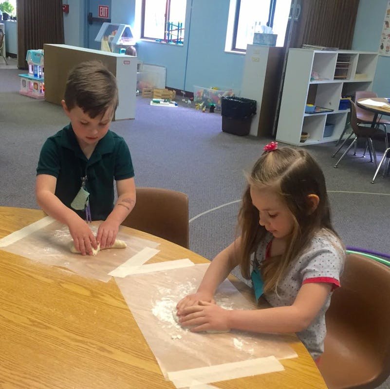 Two children working with dough at a table